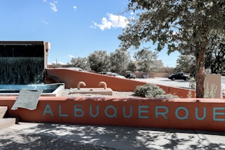 a sign that reads albuqueroque with a waterfall in the background