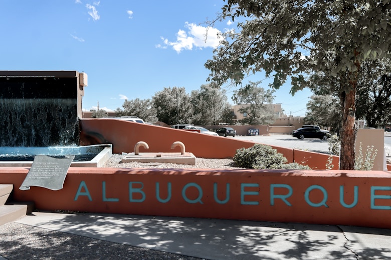 a sign that reads albuqueroque with a waterfall in the background