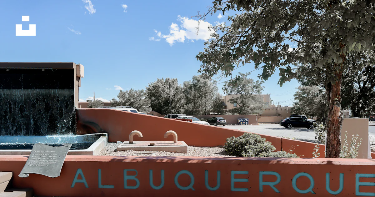 A sign that reads albuqueroque with a waterfall in the background photo ...