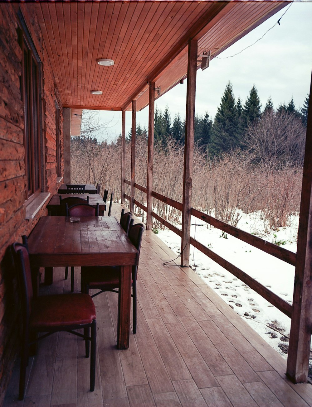 a long wooden table sitting on top of a wooden porch