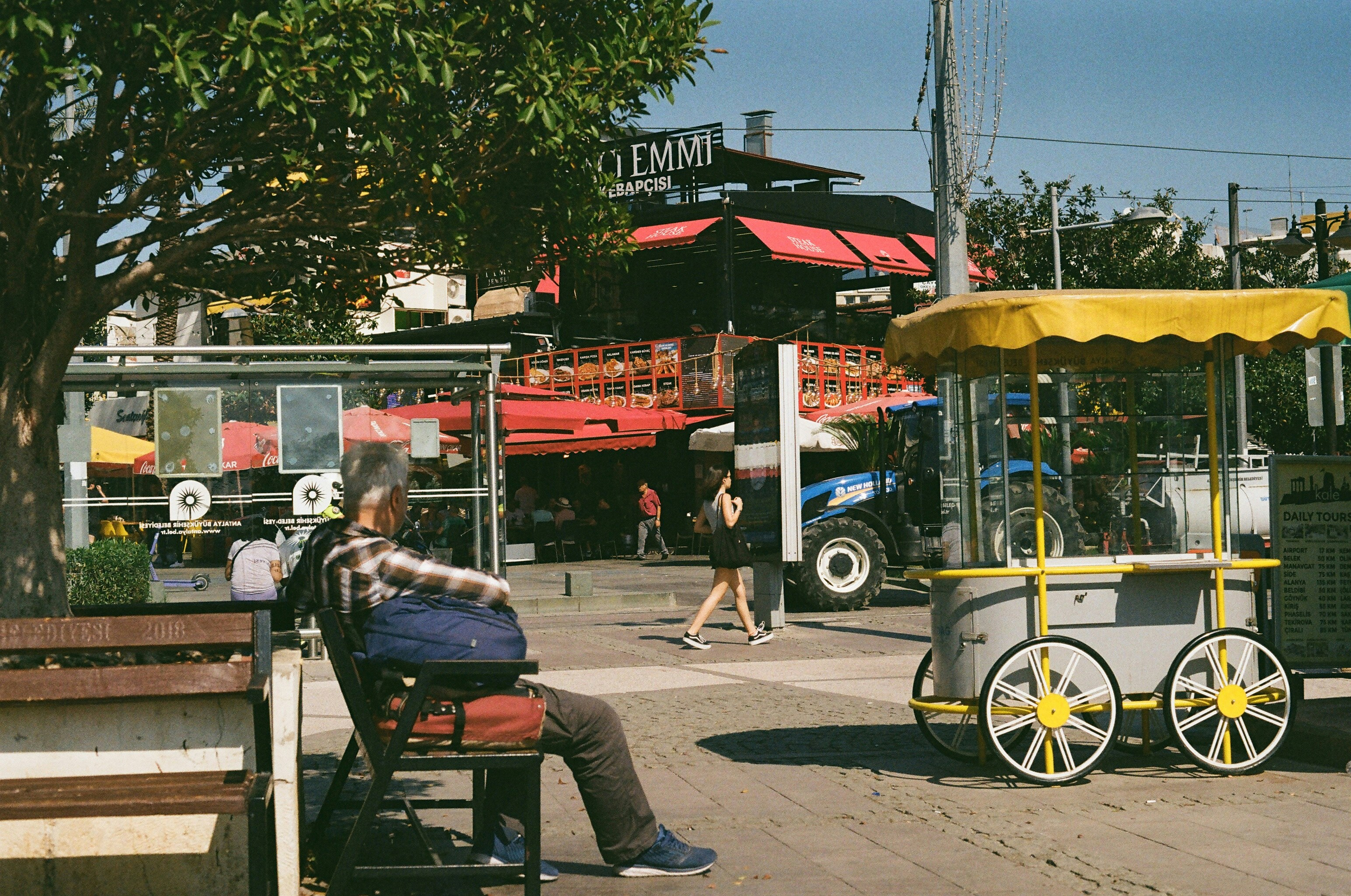 a man sitting on a bench next to a cart