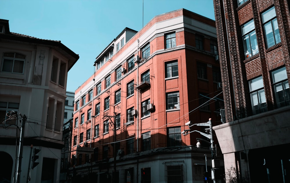 a tall red brick building sitting next to tall buildings