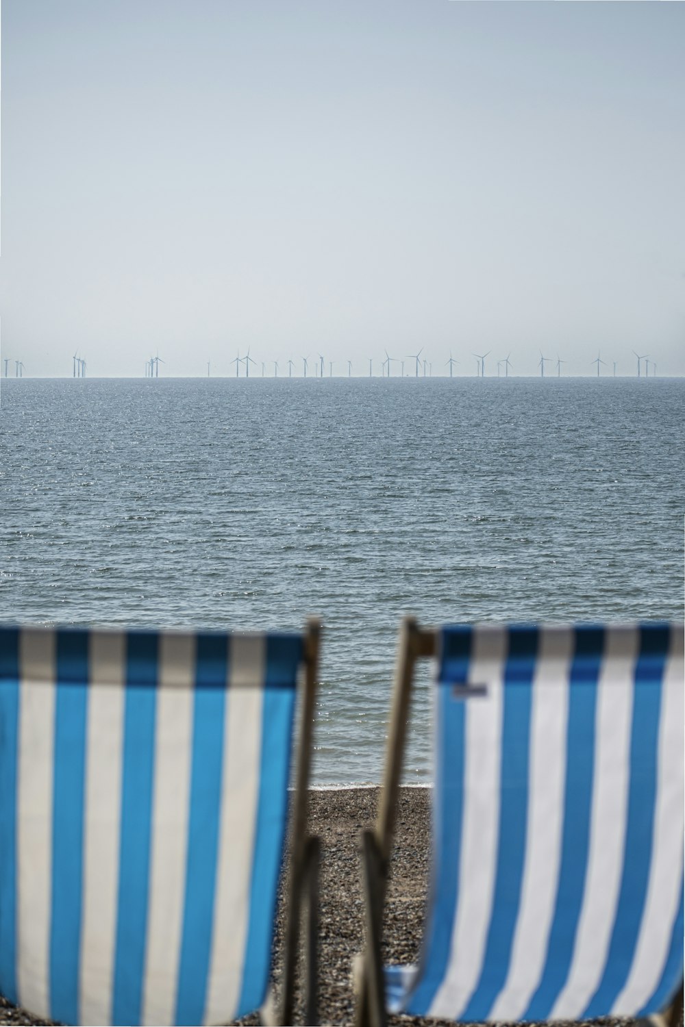 a couple of chairs sitting on top of a beach