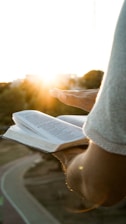 a person holding an open book in their hand