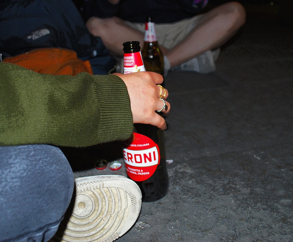 une personne tenant une bouteille de bière à la main