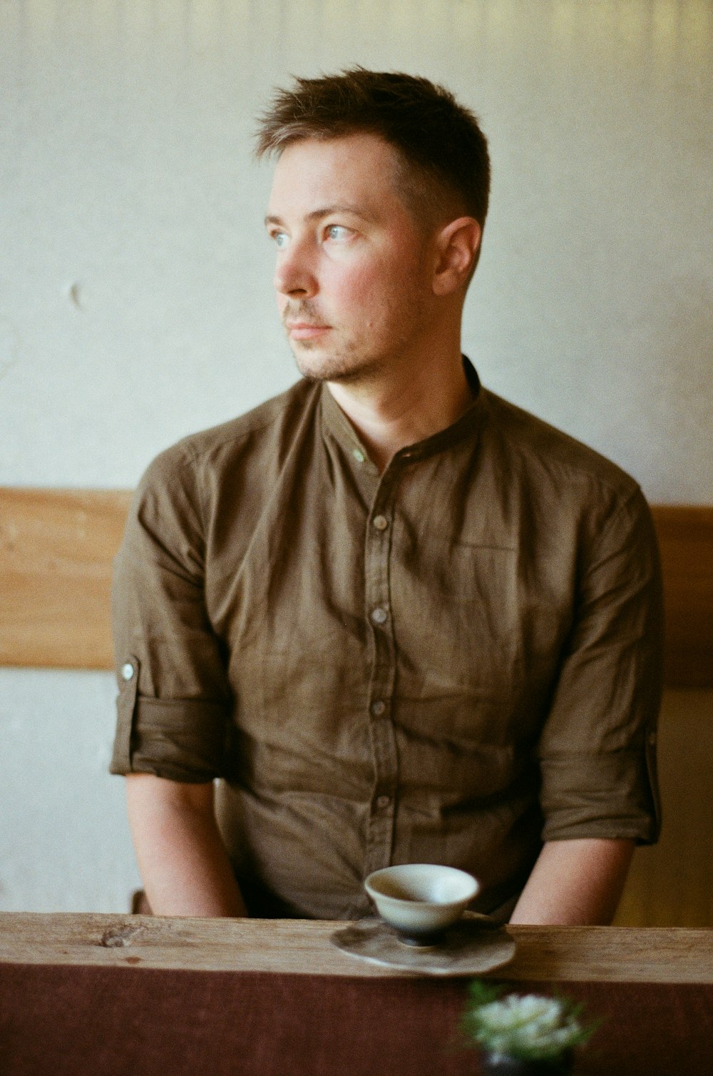 a man sitting at a table with a cup of coffee