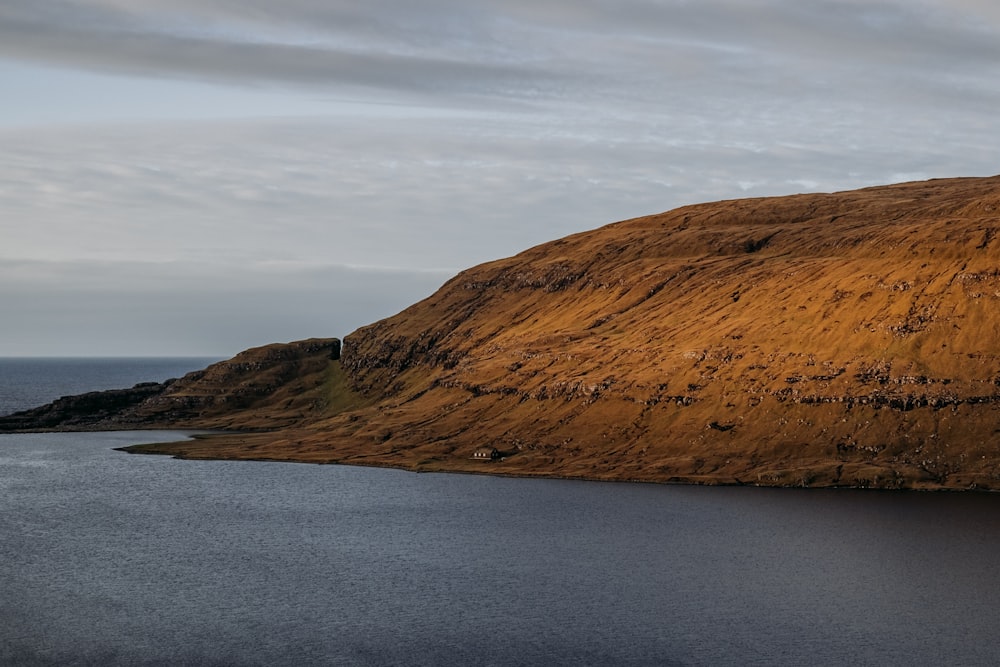 a body of water with a hill in the background