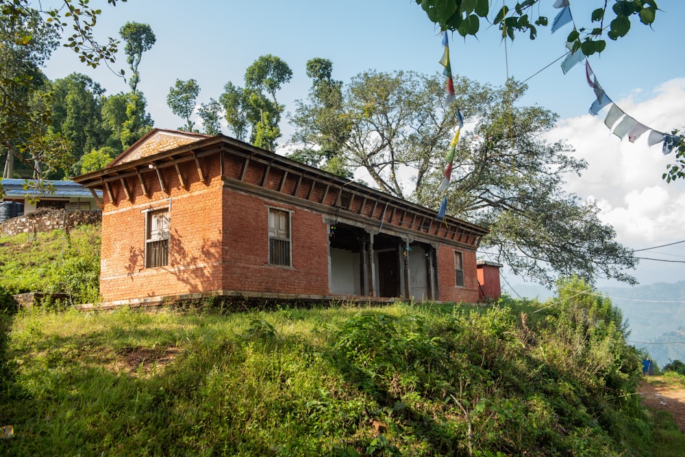 a red brick building sitting on top of a lush green hillside