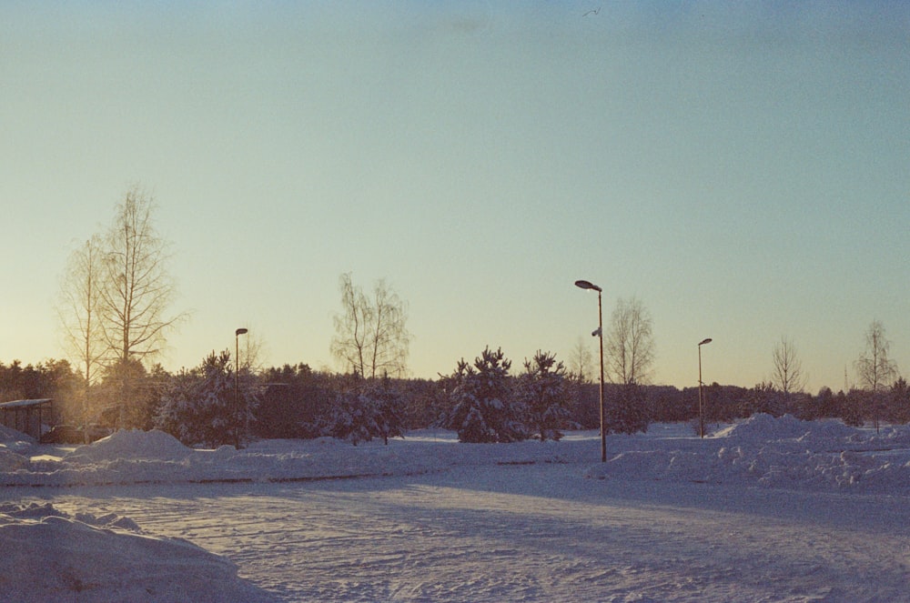 a snow covered field with a street light in the distance
