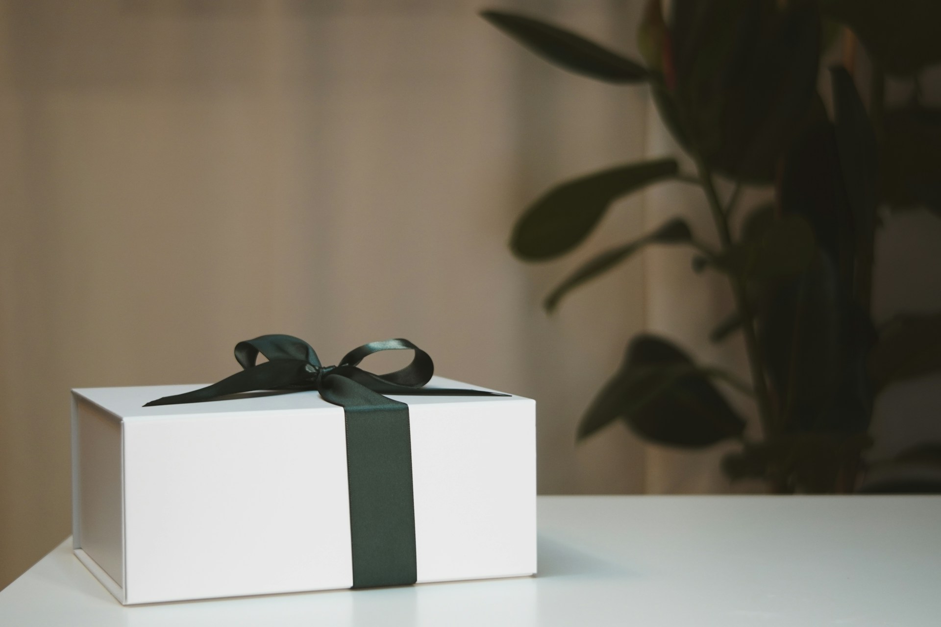 a white box with a black ribbon on a table