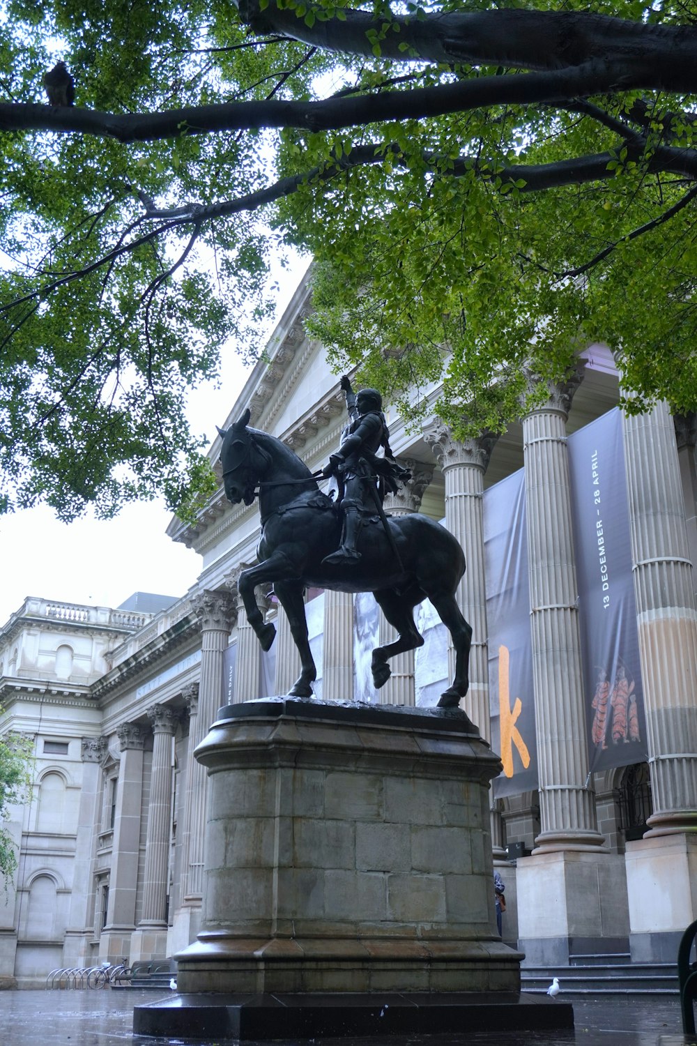 a statue of a man on a horse in front of a building