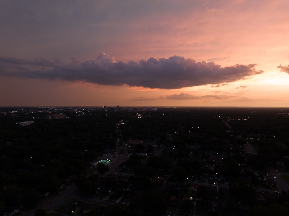 the sun is setting over a city in the distance