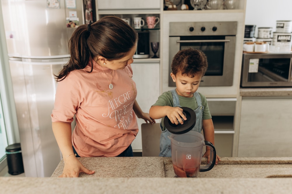 a woman and a boy are in the kitchen