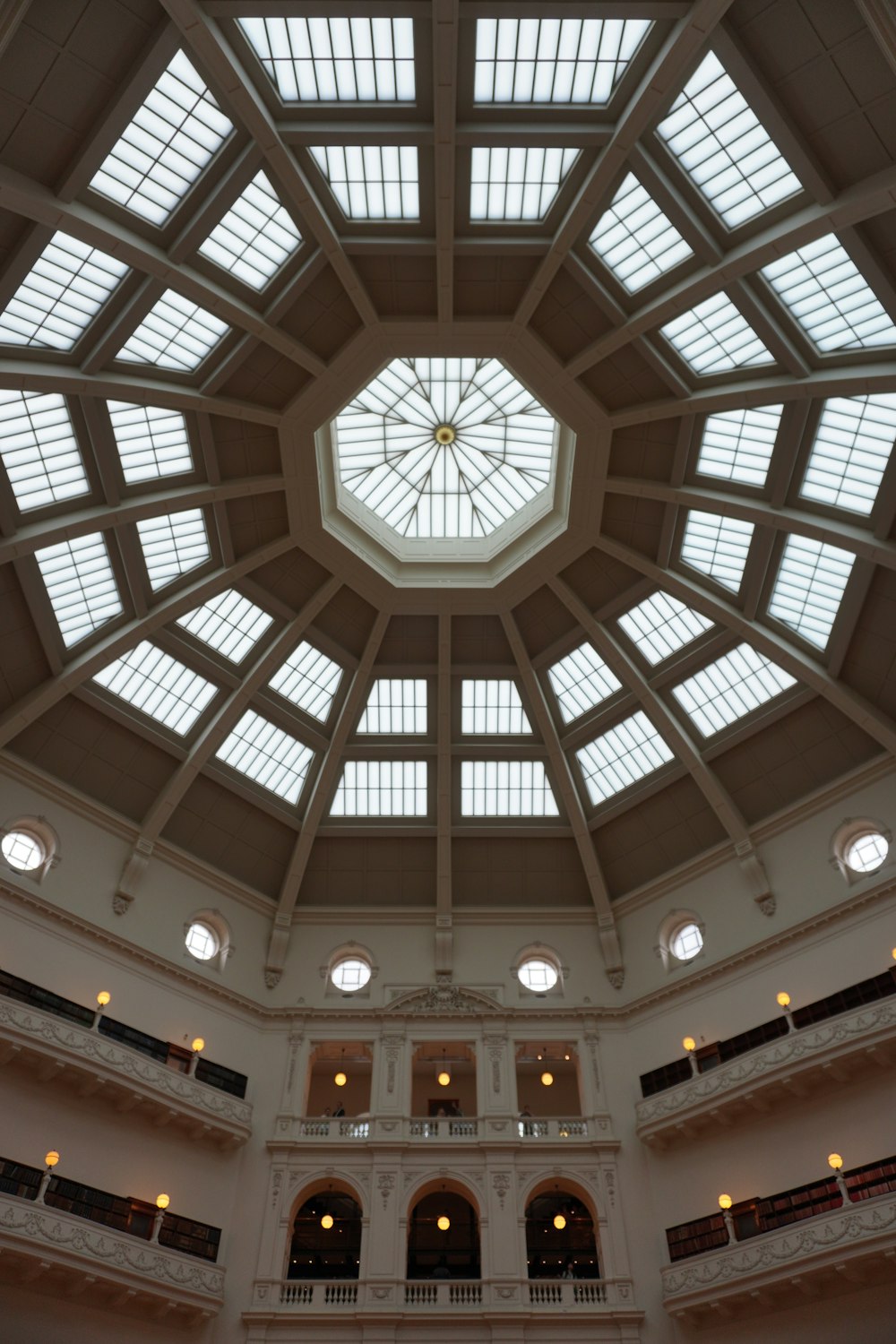 the ceiling of a large building with many windows