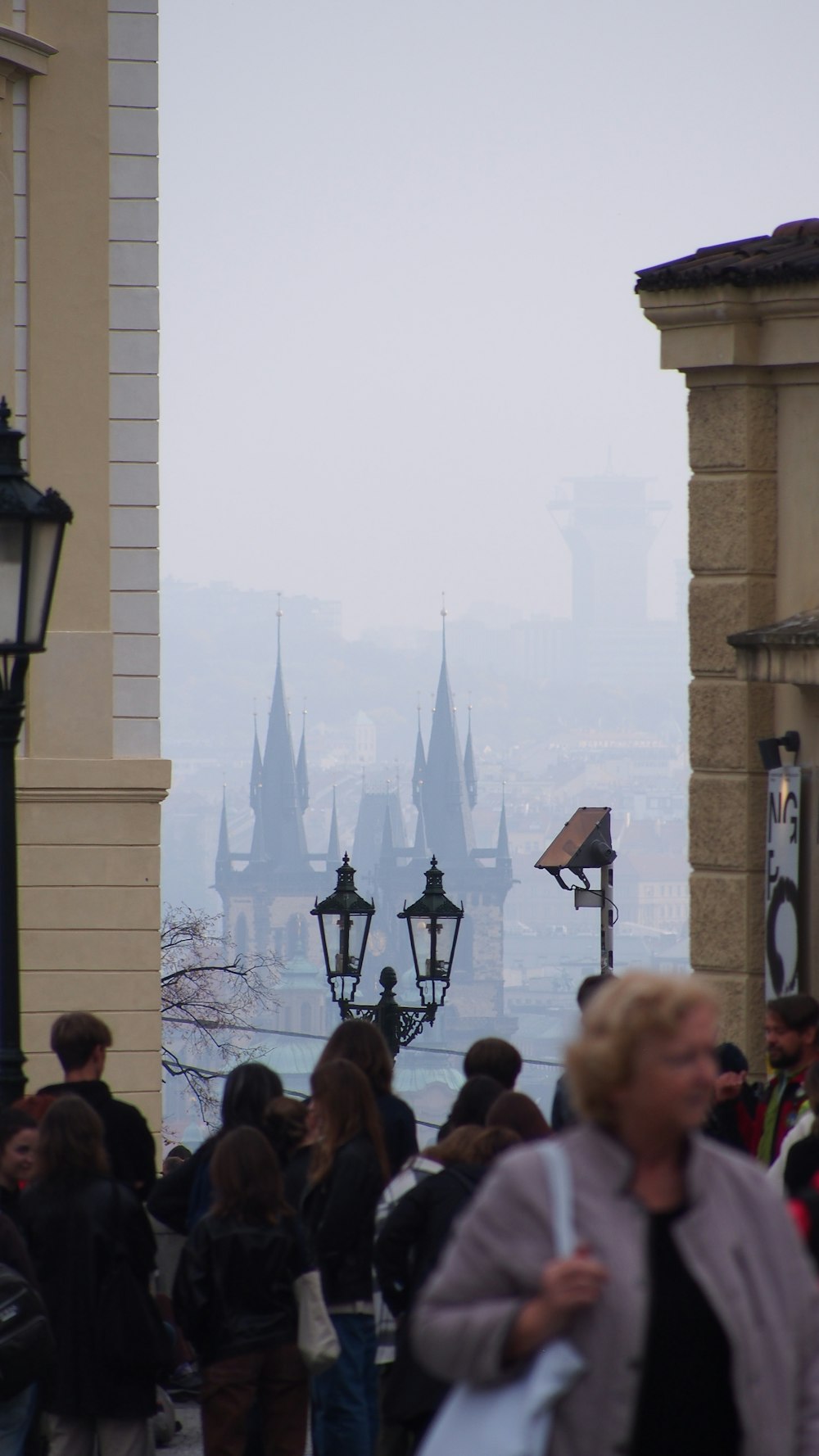 a group of people walking down a street next to tall buildings