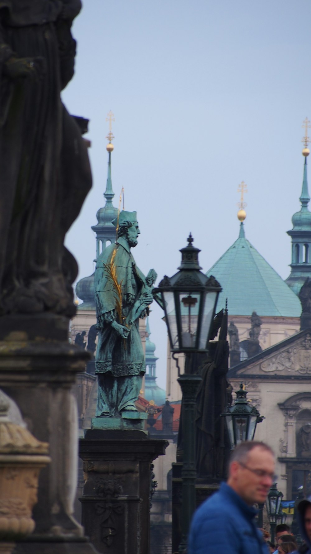 a statue of a man standing next to a lamp post