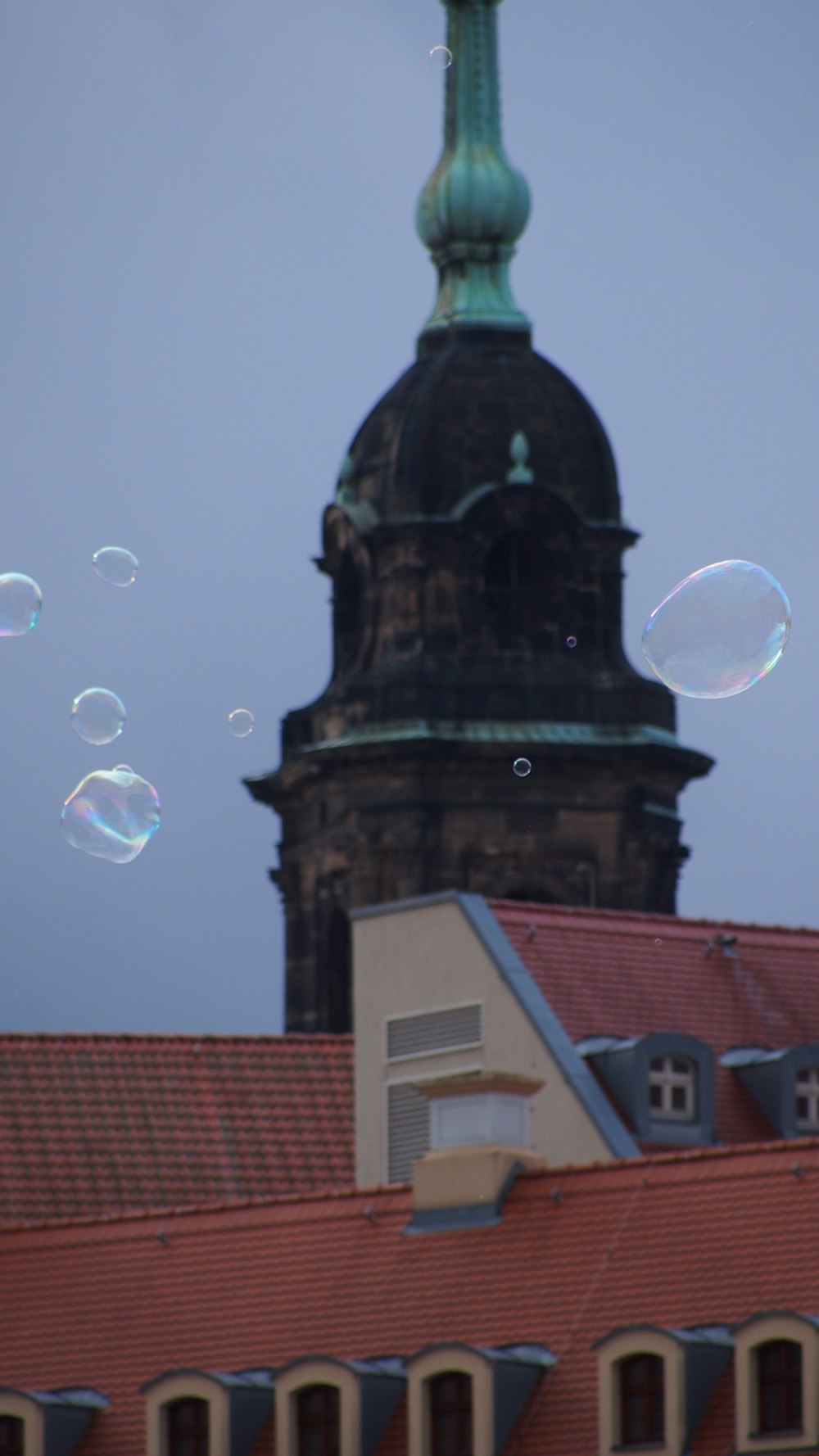 a building with a clock tower and a lot of bubbles in the air