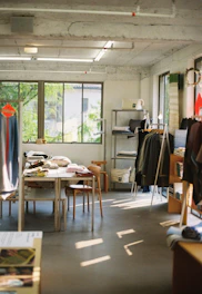 a room with a table and chairs and a large window