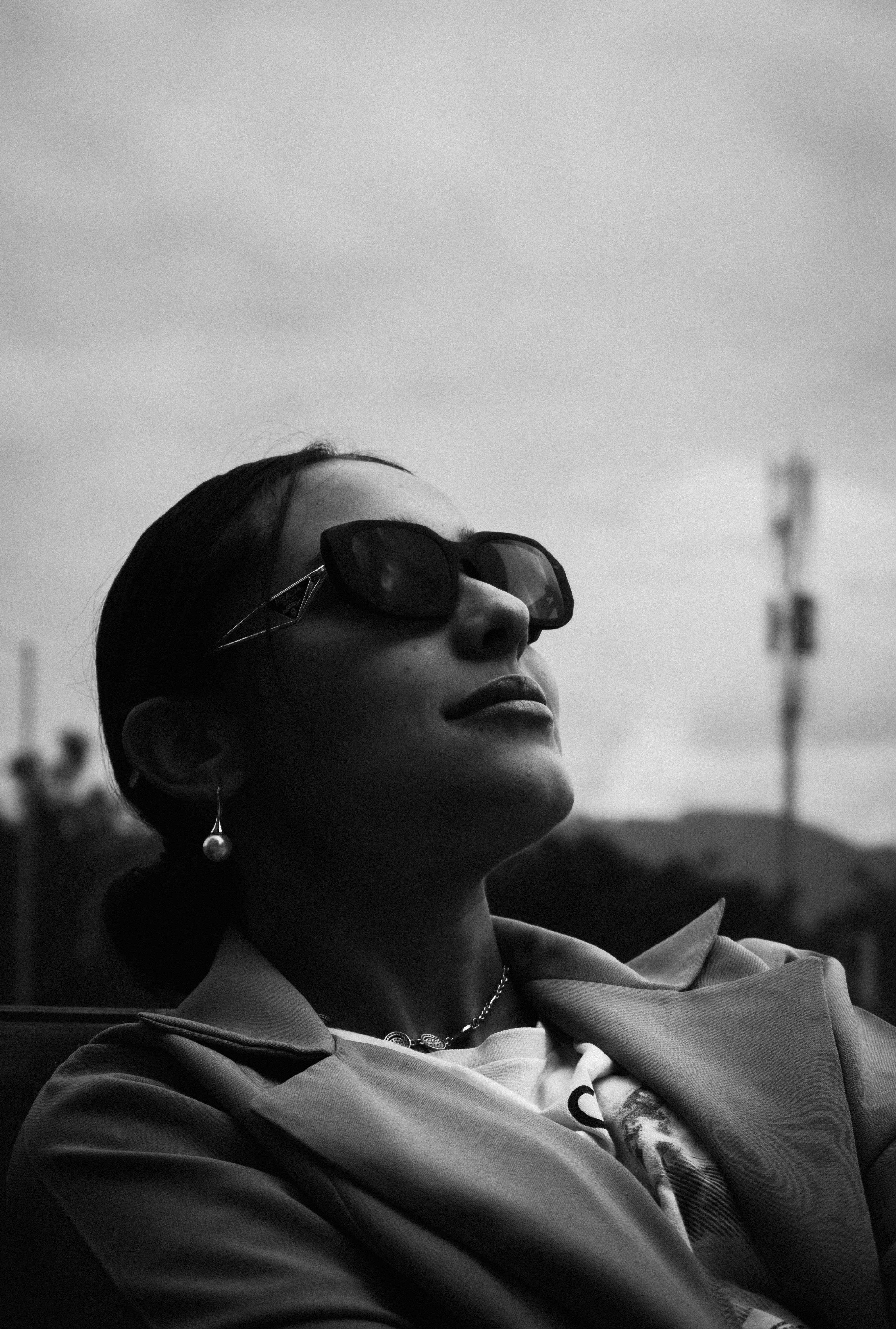 a woman wearing sunglasses is sitting down