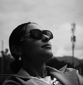 a woman wearing sunglasses is sitting down