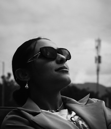 a woman wearing sunglasses is sitting down