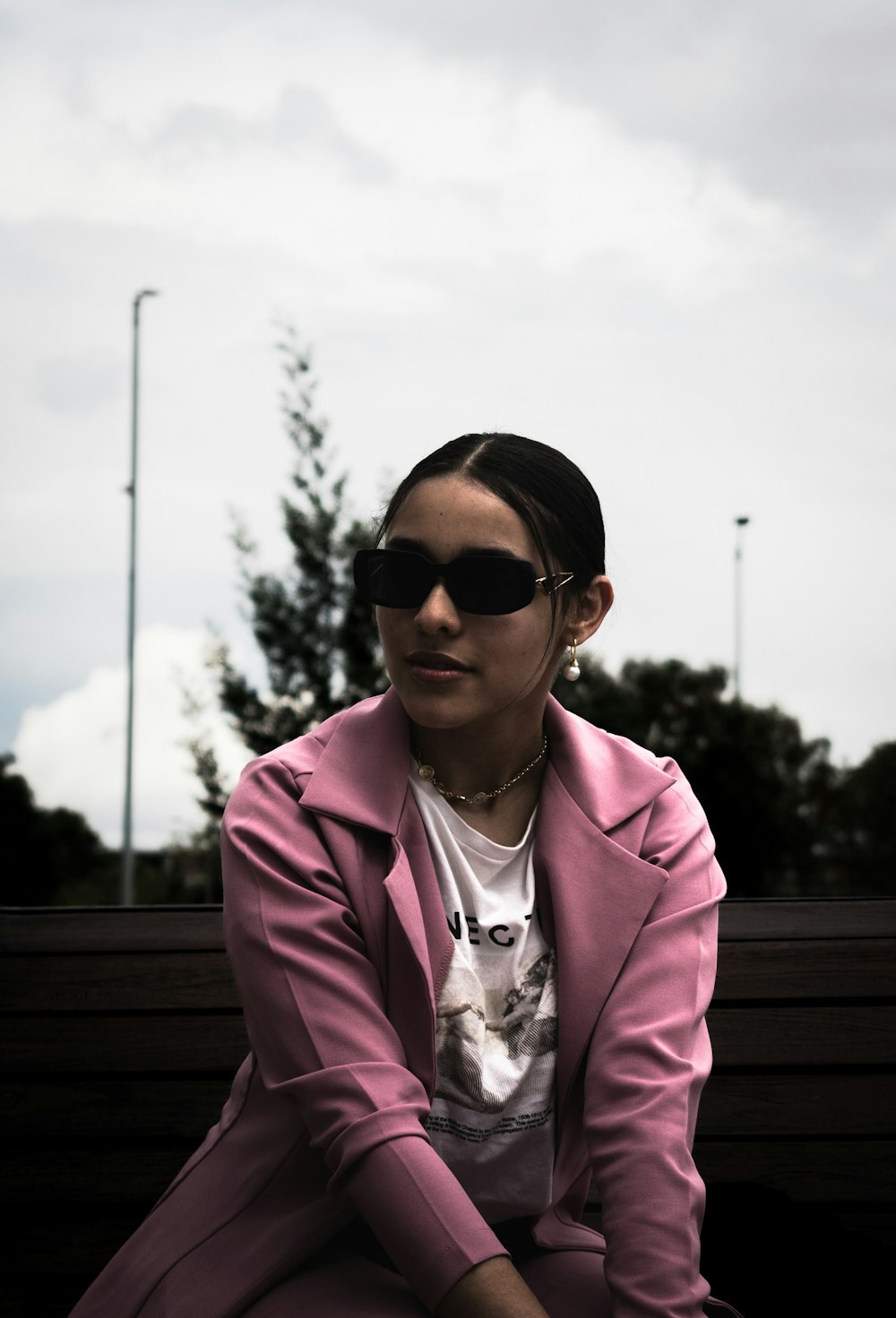 Une femme portant des lunettes de soleil assise sur un banc