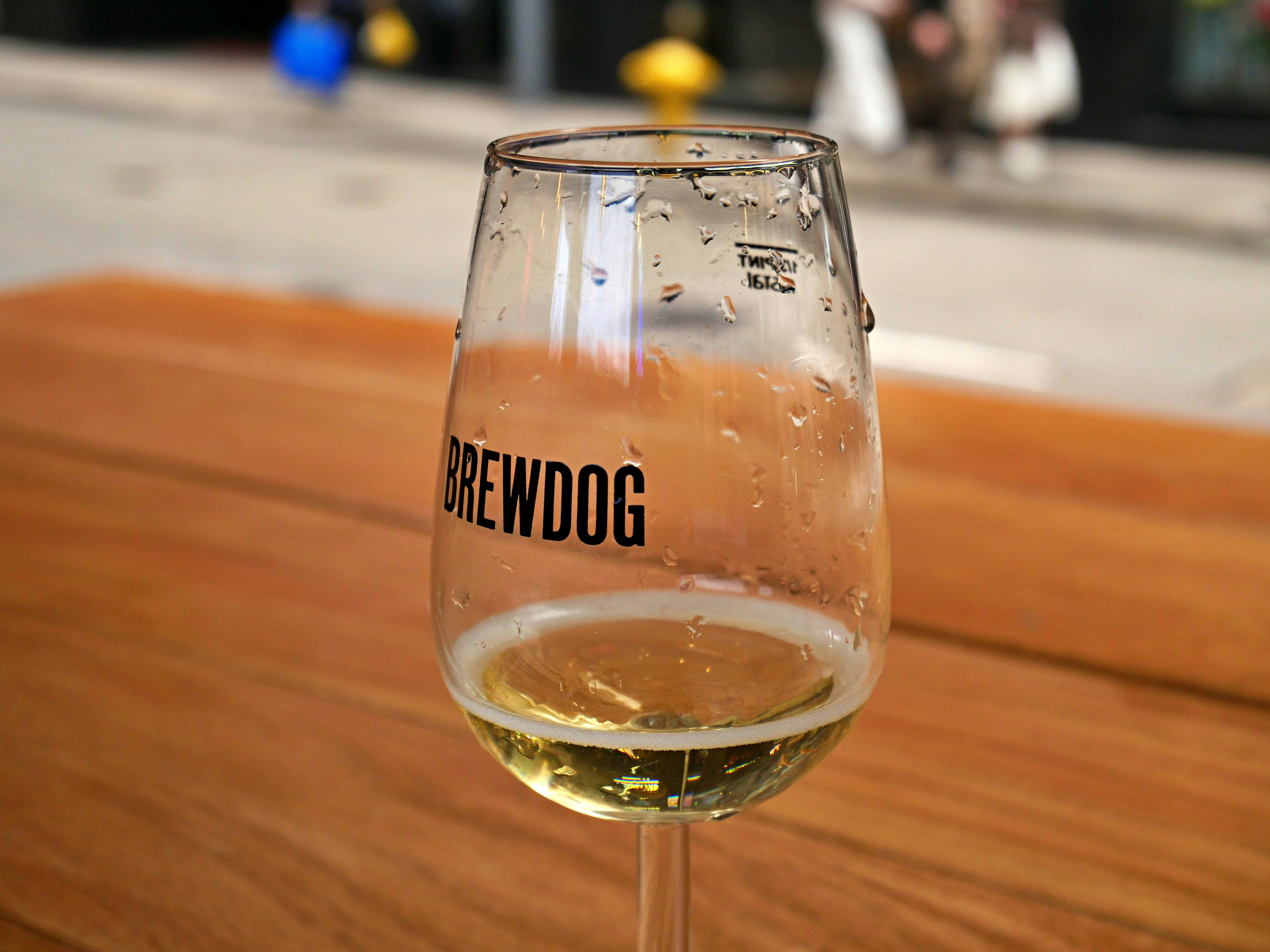 a glass of wine sitting on top of a wooden table