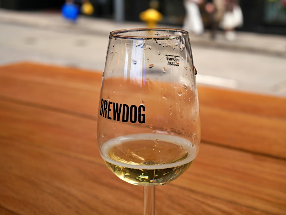 a glass of wine sitting on top of a wooden table