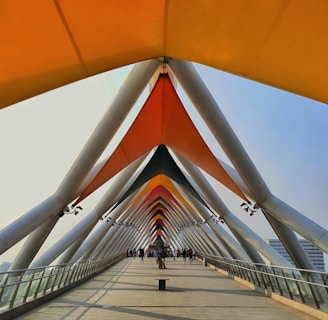a walkway that has a large orange structure on top of it