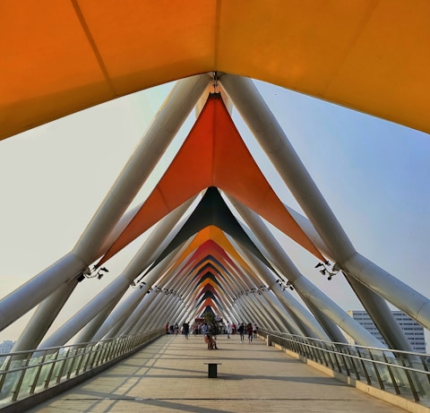 a walkway that has a large orange structure on top of it