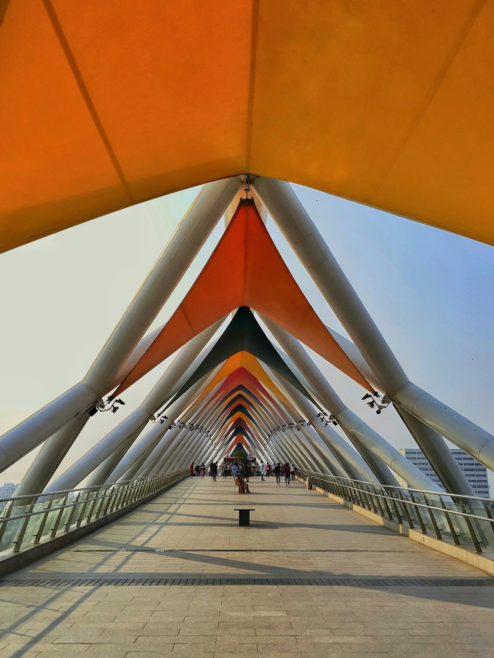 a walkway that has a large orange structure on top of it