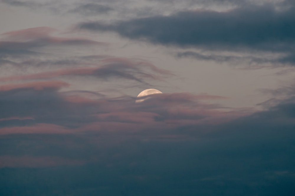 uma lua cheia é vista através de um céu nublado