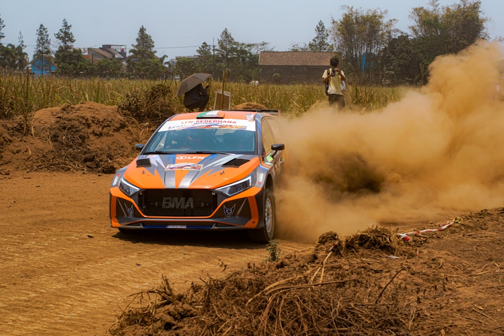 a car driving down a dirt road next to a pile of dirt