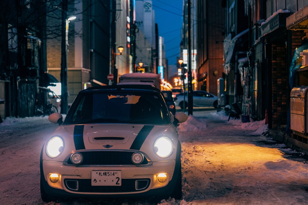 a white and black car driving down a snow covered street