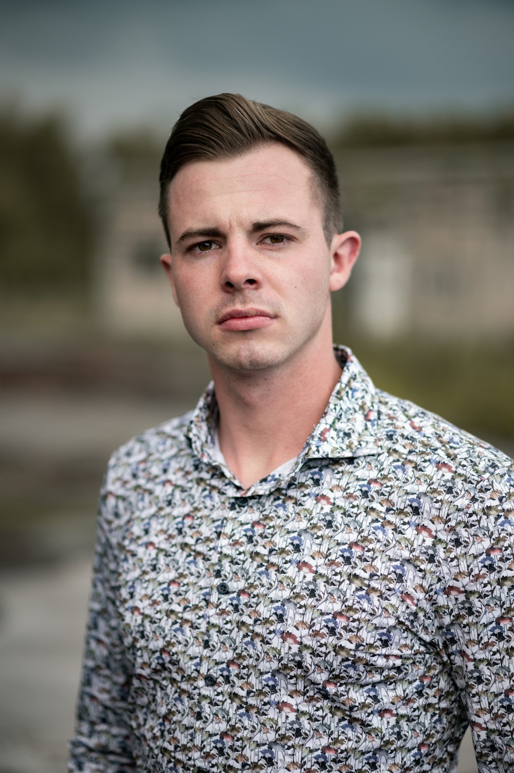 a man in a floral shirt looking at the camera