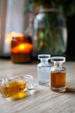three bottles of oil sitting on top of a wooden table