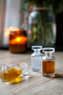 three bottles of oil sitting on top of a wooden table