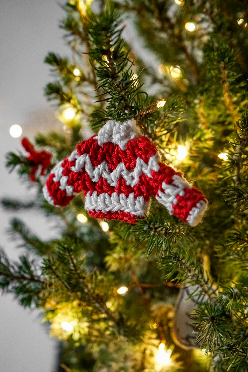 a knitted ornament hanging from a christmas tree