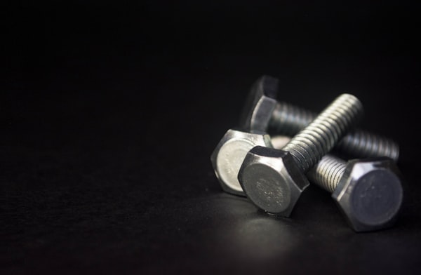 Hex cap screws on dark background — fastener detail