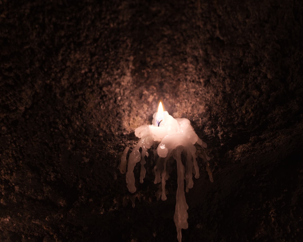a candle is lit in a dark cave