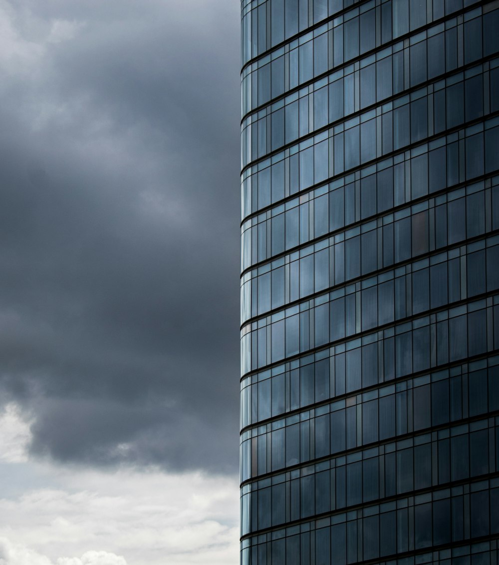 a very tall building with a very cloudy sky in the background