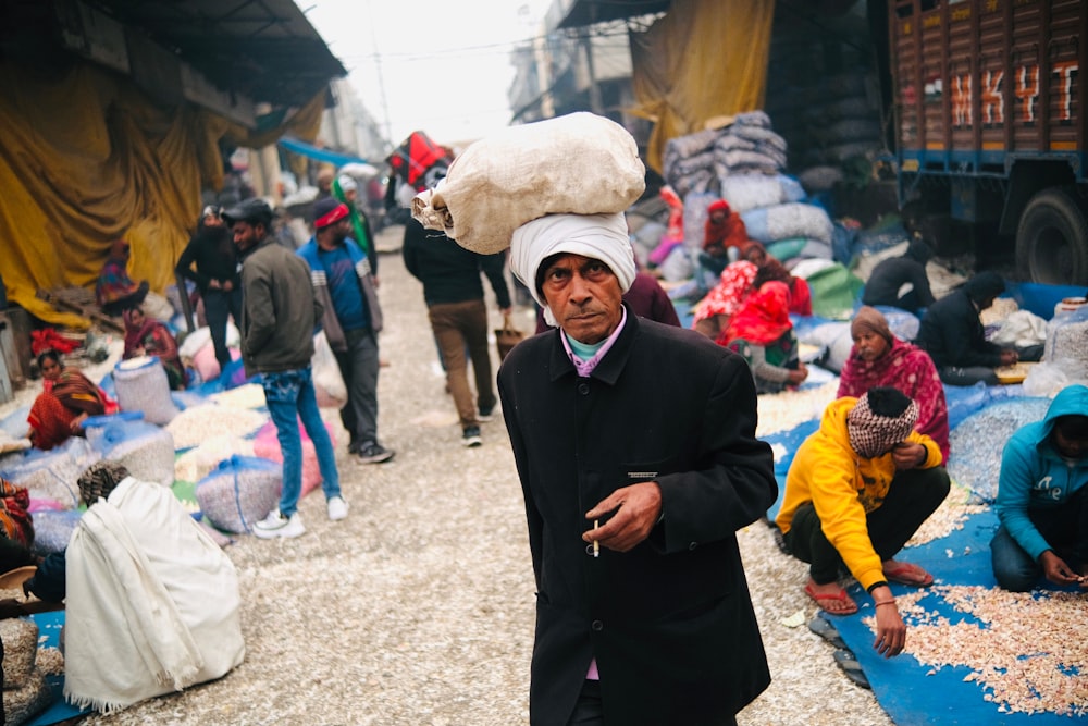 a man in a white turban walks down a street