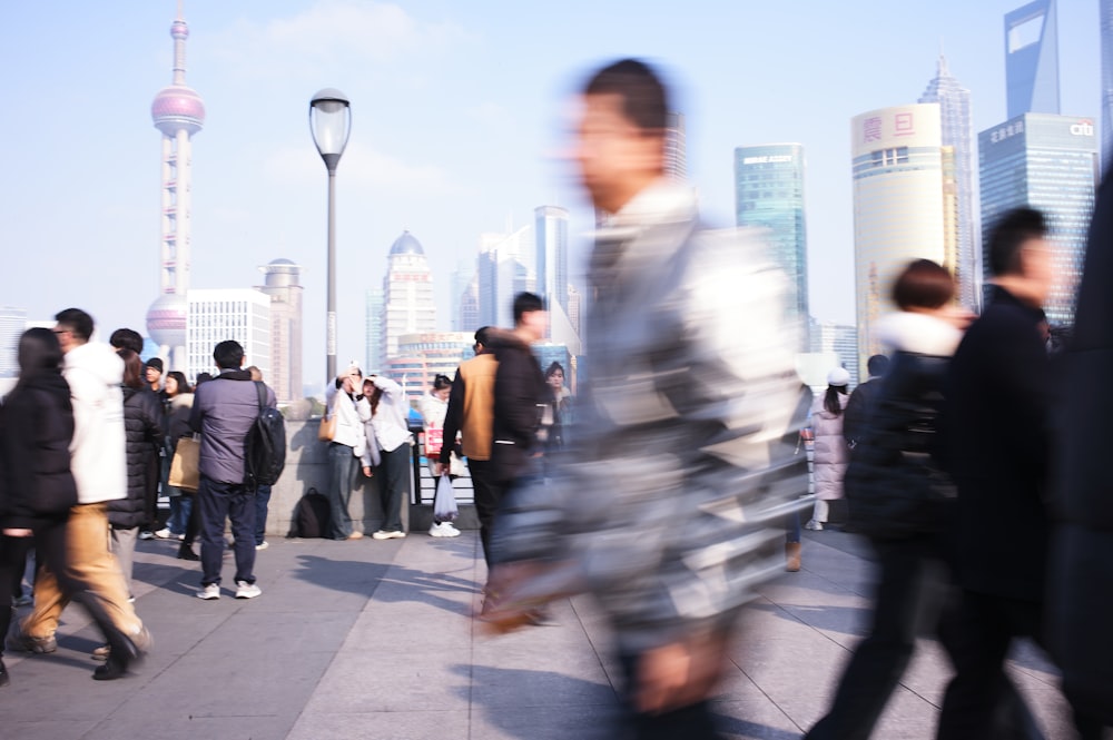 a crowd of people walking across a bridge