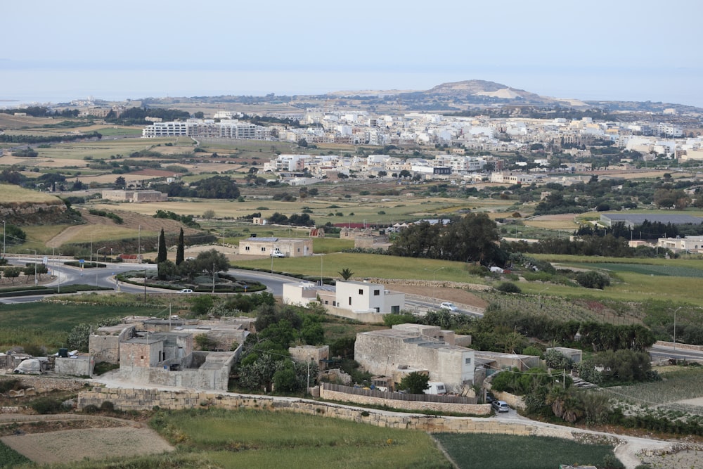 an aerial view of a city with a hill in the background