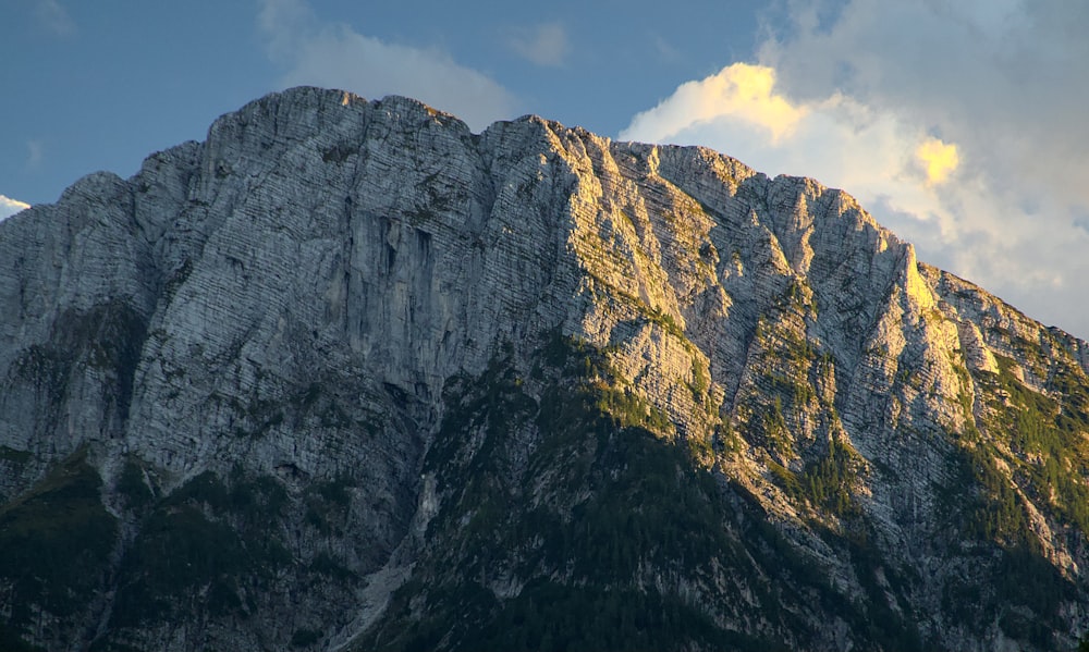 a very tall mountain with some clouds in the sky