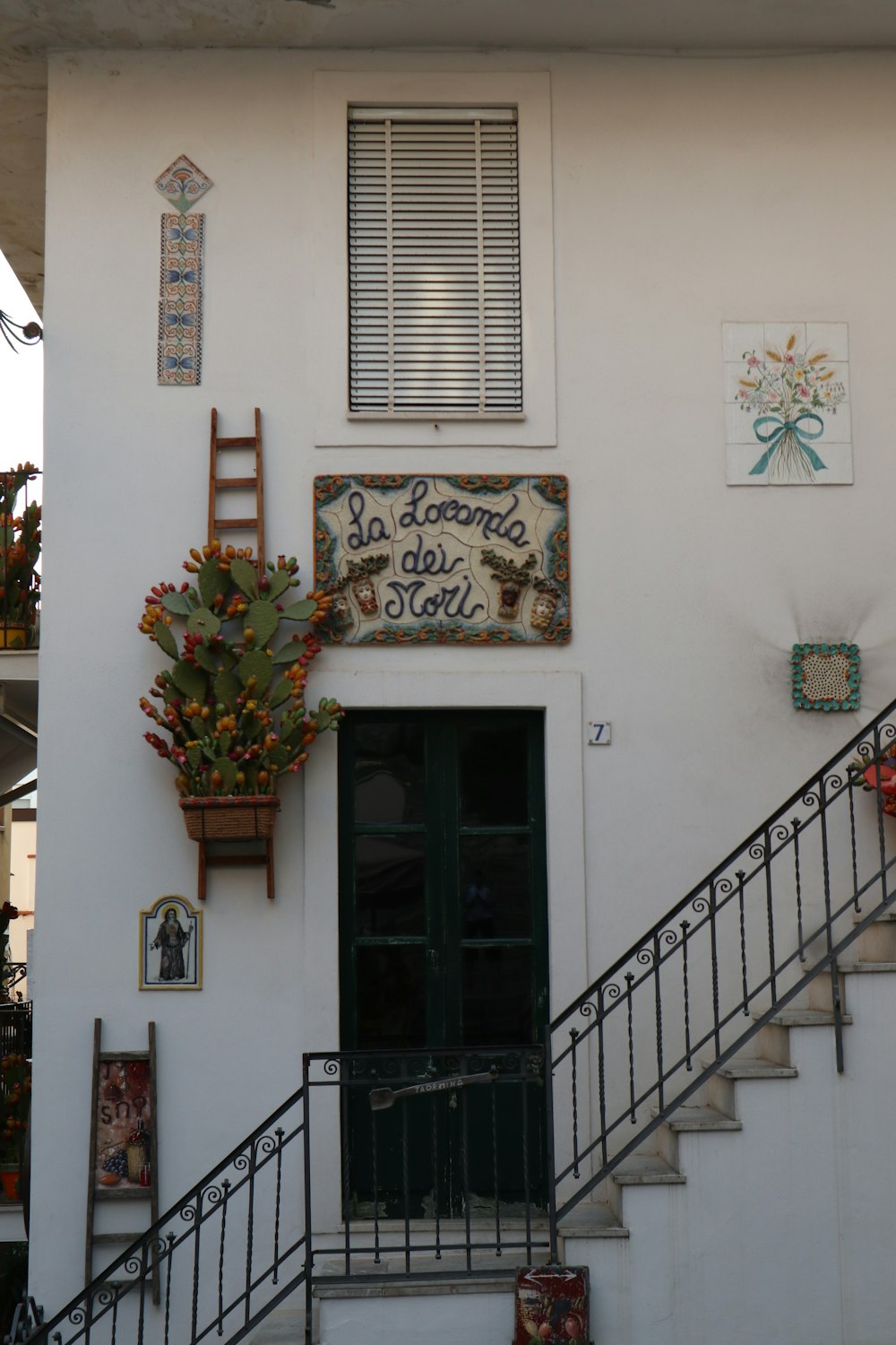 a white building with a green door and stairs