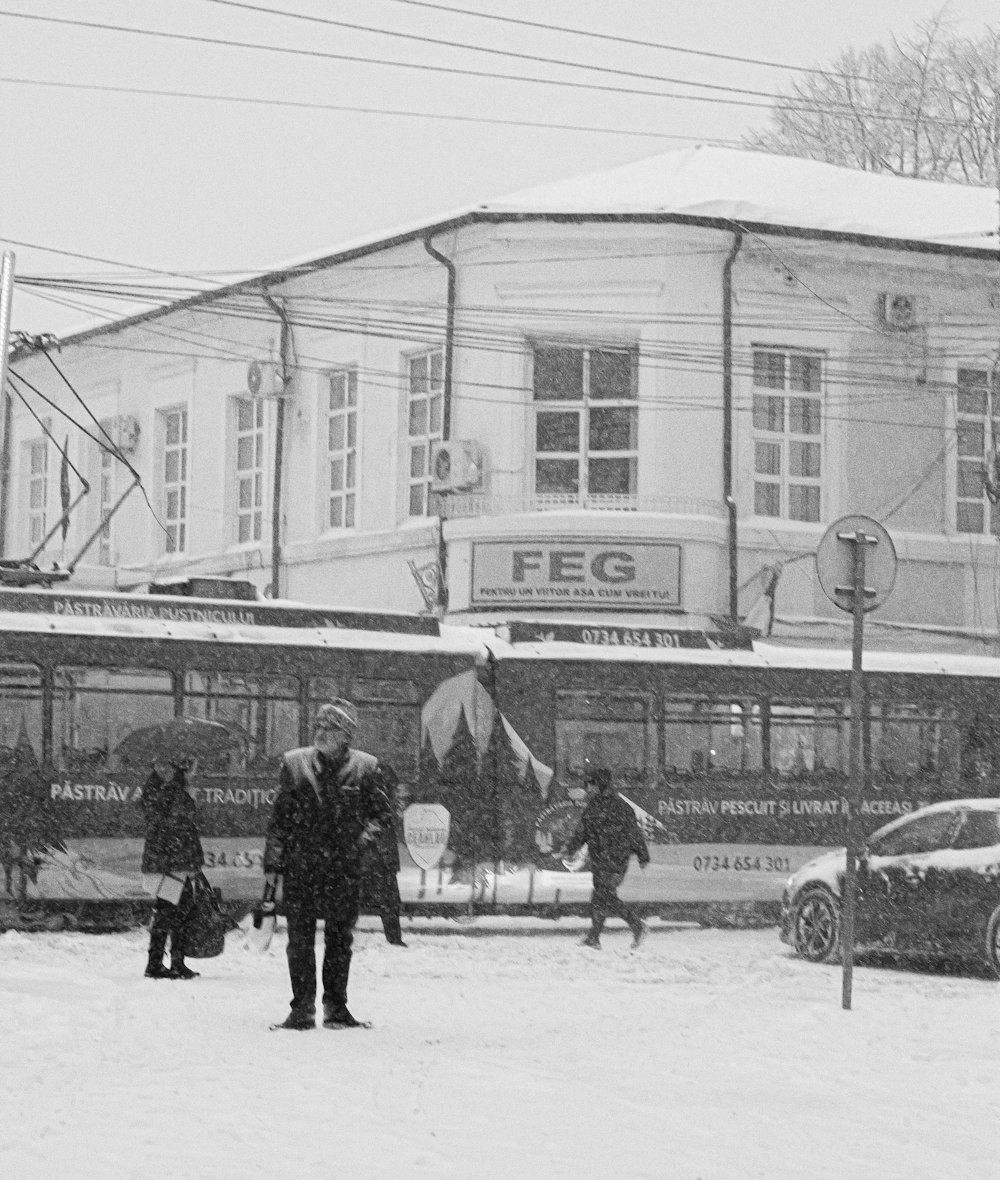 a black and white photo of people standing in the snow