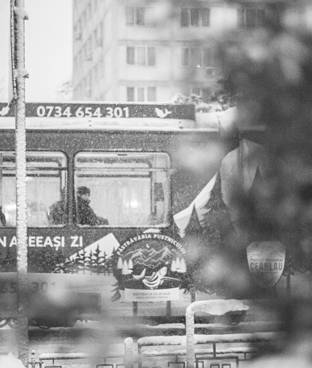 a black and white photo of a bus in the rain