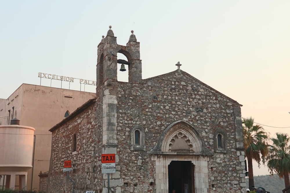 an old church with a bell tower and palm trees