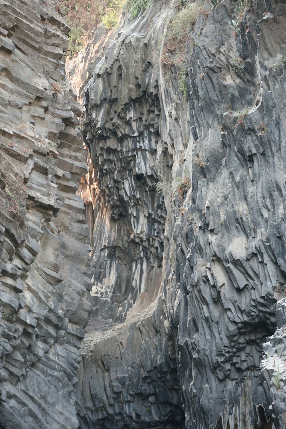 a rocky cliff with a boat in the water